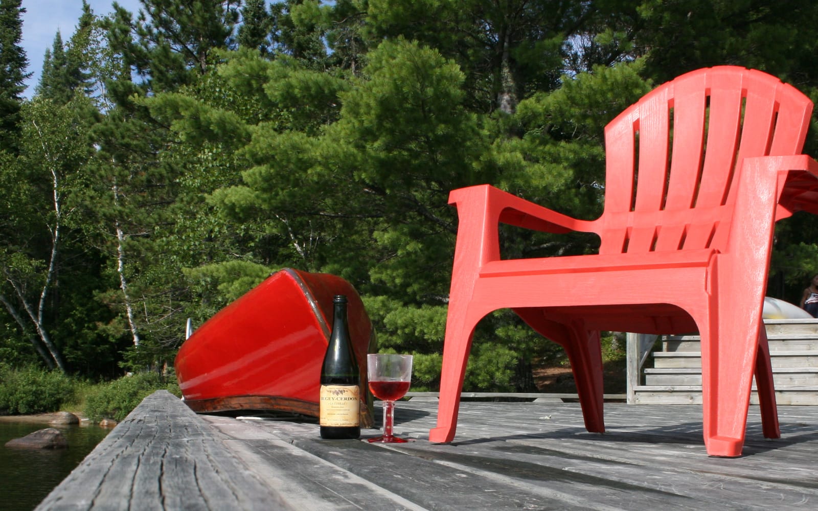 Two red chairs and a bottle of wine set out at golden hour