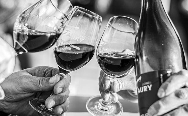 Black and white photograph of red wine poured into glasses