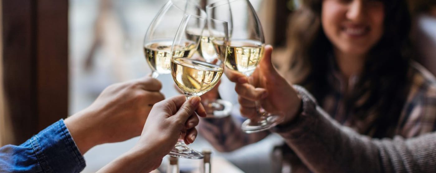 Friends raising glasses of white wine together